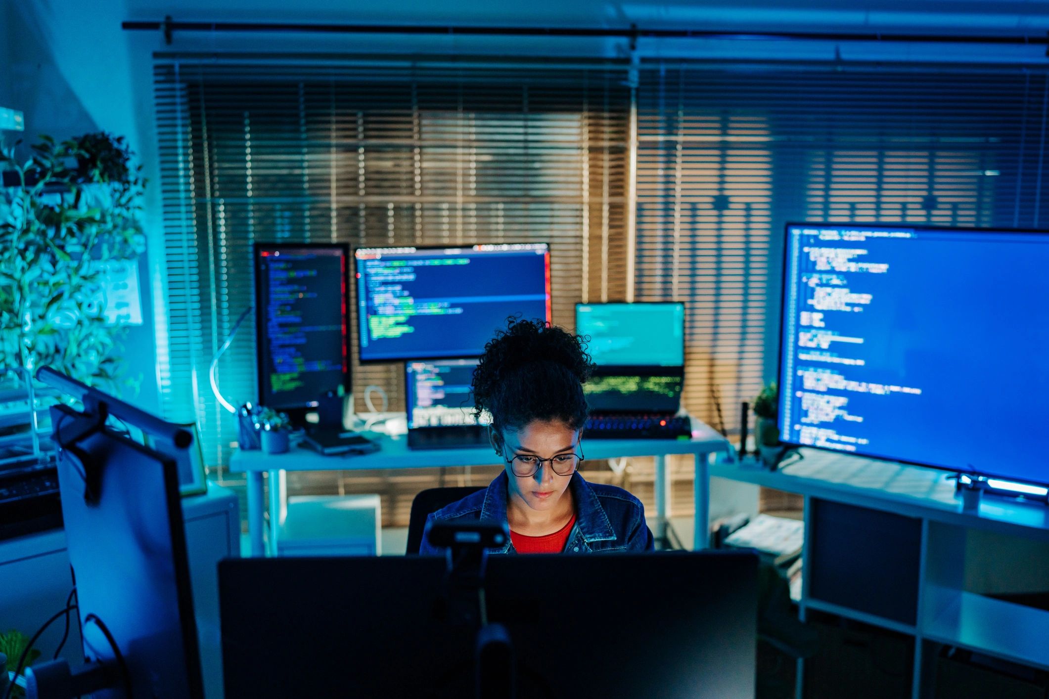 IT professional working at a multi-monitor workstation representing security monitoring